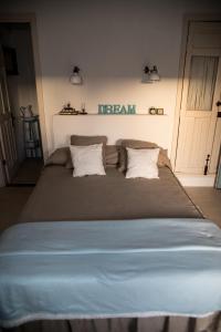 a large bed with two pillows and a dream sign on the wall at Casa Leandra con jacuzzi in Adeje