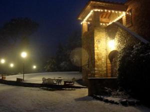 un edificio con luces en la nieve en Agriturismo Sant'illuminato, en Calzolaro