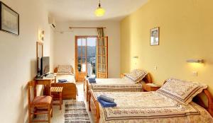 a room with four beds and a television in it at Captain Spiros Studios in Paleokastritsa