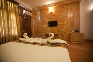 three white swans sitting on top of a bed at Symphony Palms Beach Resort And Spa in Havelock Island