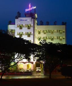 een hotel met een neonbord erop bij Bhasuri Inn Guruvayoor in Guruvāyūr