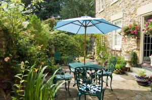 uma mesa e cadeiras com um guarda-sol num jardim em Castle View Guesthouse em Durham