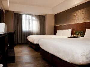 una camera d'albergo con due letti e una finestra di KDM Hotel a Taipei