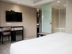 Habitación de hotel con cama y TV en KDM Hotel, en Taipéi