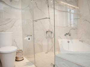 un bagno bianco con wc e doccia di KDM Hotel a Taipei