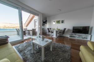 a living room with a couch and a table at Apartments Bouvier in Pag