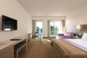 a hotel room with a bed and a living room at Melia Madeira Mare in Funchal