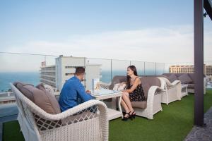 a man and a woman sitting at a table on a balcony at Fénix Torremolinos - Adults Only Recommended in Torremolinos