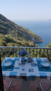 a table with plates and flowers on top of a balcony at Acquamarina Accommodation in Massa Lubrense