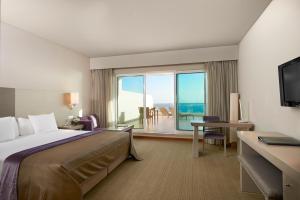 a hotel room with a bed and a view of the ocean at Melia Madeira Mare in Funchal