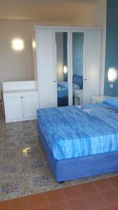a bedroom with a blue bed and a mirror at Acquamarina Accommodation in Massa Lubrense