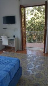 a bedroom with a bed and a desk and a sliding glass door at Acquamarina Accommodation in Massa Lubrense