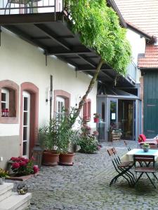 un patio al aire libre con mesa, sillas y plantas en Alter Winzerhof Weisenheim am Berg e.K., en Weisenheim am Berg