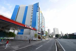 a building on a street with people walking on the street at Hop Inn Hotel Makati Avenue Manila in Manila