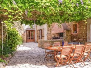 patio con tavolo e sedie sotto un pergolato di Holiday home with swimming pool a Félines-Minervois