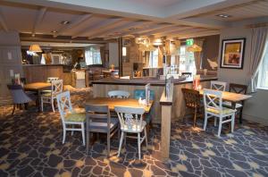 a restaurant with tables and chairs and a kitchen at Penny Hedge, Whitby by Marston's Inns in Whitby