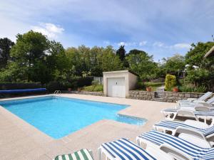 a swimming pool with lounge chairs and a swimming pool at Detached villa in a small villa estate with private swimming pool in Ruoms
