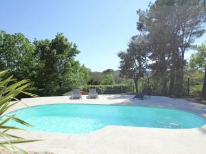 a black cat is sitting in a swimming pool at Lush villa with private pool in Bagnols-en-Forêt