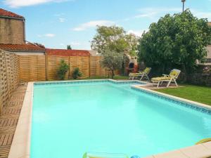 a swimming pool with two chairs and a fence at Charming holiday home in Talairan with pool in Talairan