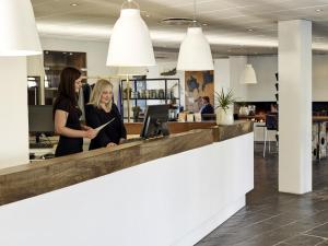 twee vrouwen aan een balie in een kantoor bij Comwell Roskilde in Roskilde