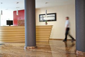 un homme qui traverse une pièce avec colonnes dans l'établissement Hotel Concorde, à Munich