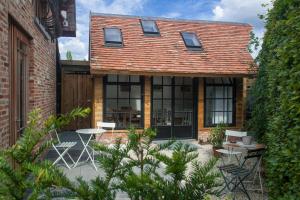 een huis met een patio met stoelen en tafels bij B&B Hildegarden in Gierle