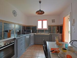 a kitchen with a table and a counter top at Cozy Villa in Saint Victor de Malcap with Swimming Pool in Saint-Victor-de-Malcap