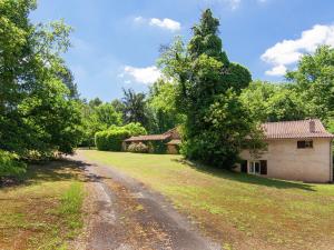 un camino de tierra que conduce a una casa y árboles en Cosy Holiday Home in Bourgnac with Private Pool, en Bourgnac