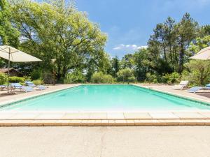 una gran piscina con sillas y sombrillas en Cosy Holiday Home in Bourgnac with Private Pool, en Bourgnac