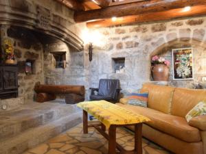 a living room with a couch and a stone wall at Cosy holiday home on the river Le Lignon in La Souche