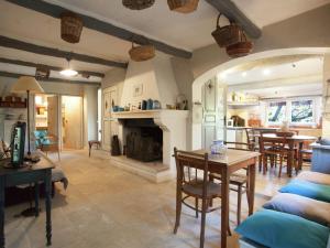 MaubecにあるCottage in Oppède with Pool and Gardenの暖炉とテーブルと椅子のあるリビングルーム