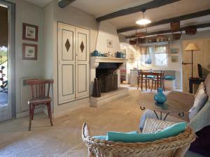 a living room with a fireplace and a table and chairs at Rustic Cottage in Oppede with Shared Pool in Maubec