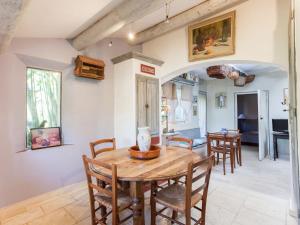 a kitchen and dining room with a wooden table and chairs at Rustic Cottage in Oppede with Shared Pool in Maubec