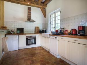 a kitchen with white cabinets and a tile floor at Holiday home with private terrace in Saint-Aignan