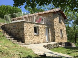 a stone building with a balcony on top of it at Stunning Cottage in Tavistock with Private Terrace and Garden in Saint-Pierre-de-Colombier