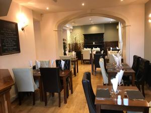 a restaurant with wooden tables and chairs and a chalkboard at Aberdunant Hall in Porthmadog