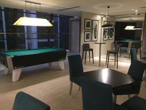 a living room with a pool table and chairs at Great Value Family Apartment to Family Apartment @ M-City in Kuala Lumpur