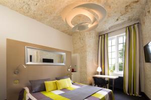 une chambre avec un lit avec une couverture jaune et grise dans l'établissement Hotel Les Hautes Roches, à Rochecorbon