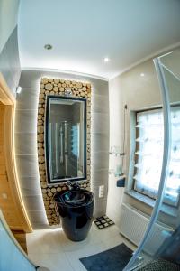 uma casa de banho com um lavatório e um espelho em Dom Jeziorna em Lubiatów