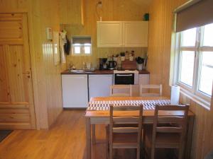 - une cuisine avec une table et des chaises dans la chambre dans l'établissement Lækjaborgir Guesthouse, à Kálfafell