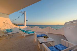 Un balcón con sillas y vistas al océano. en Aristodimos Luxury Suite, en Kalamaki