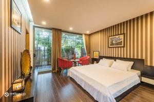 een slaapkamer met een bed en een tafel en stoelen bij Flamingo Villa Happy in Ngọc Quang