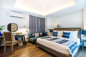 a bedroom with a bed and a desk and a chair at NH Collection Samui Peace Resort in Bophut