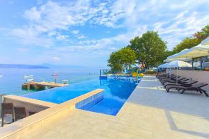 a swimming pool with chairs and a view of the water at Glavotok Premium Green Camp in Krk