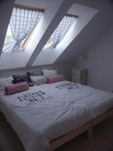 a bedroom with a large bed with two windows at Dom pod Skrzydłami in Gawliki Wielkie