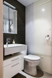 La salle de bains est pourvue de toilettes blanches et d'un lavabo. dans l'établissement Kite View, à Noordwijk aan Zee