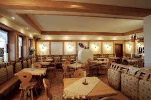 un ristorante con tavoli e sedie in una stanza di Hotel Camoscio a Rocca Pietore