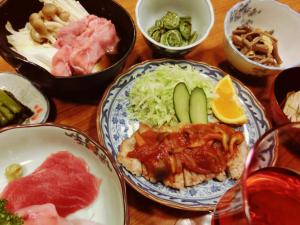 una mesa de madera con platos de comida. en Oyado Uemasa, en Nozawa Onsen