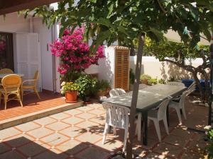 un tavolo e sedie su un patio fiorito di Can Gatet a Colonia Sant Jordi