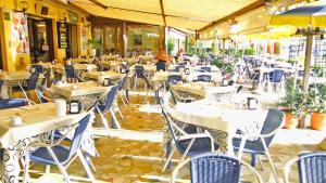 an empty restaurant with white tables and chairs at Hotel Sole - Limone in Limone sul Garda